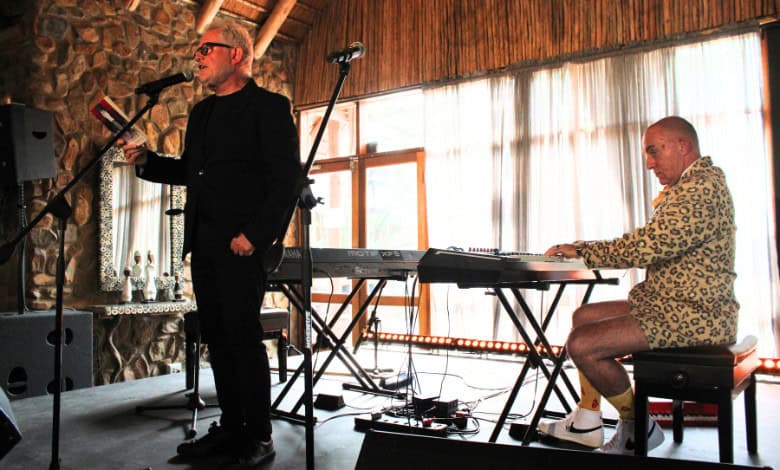 Coenie de Villiers lees sy gedig voor terwyl Rocco de Villiers klavier speel.