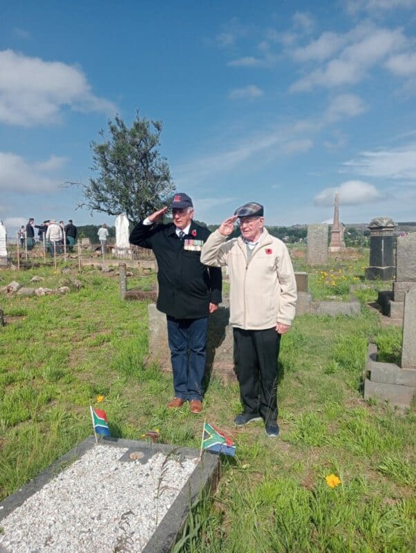 Corrie van Rooyen and Dick Latré salute at Shane Latré's grave.
