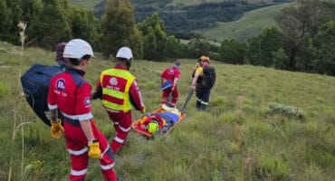The SARZA team and paramedics with a learner who was rescued after a 30m fall. > Photo: Supplied/SARZA