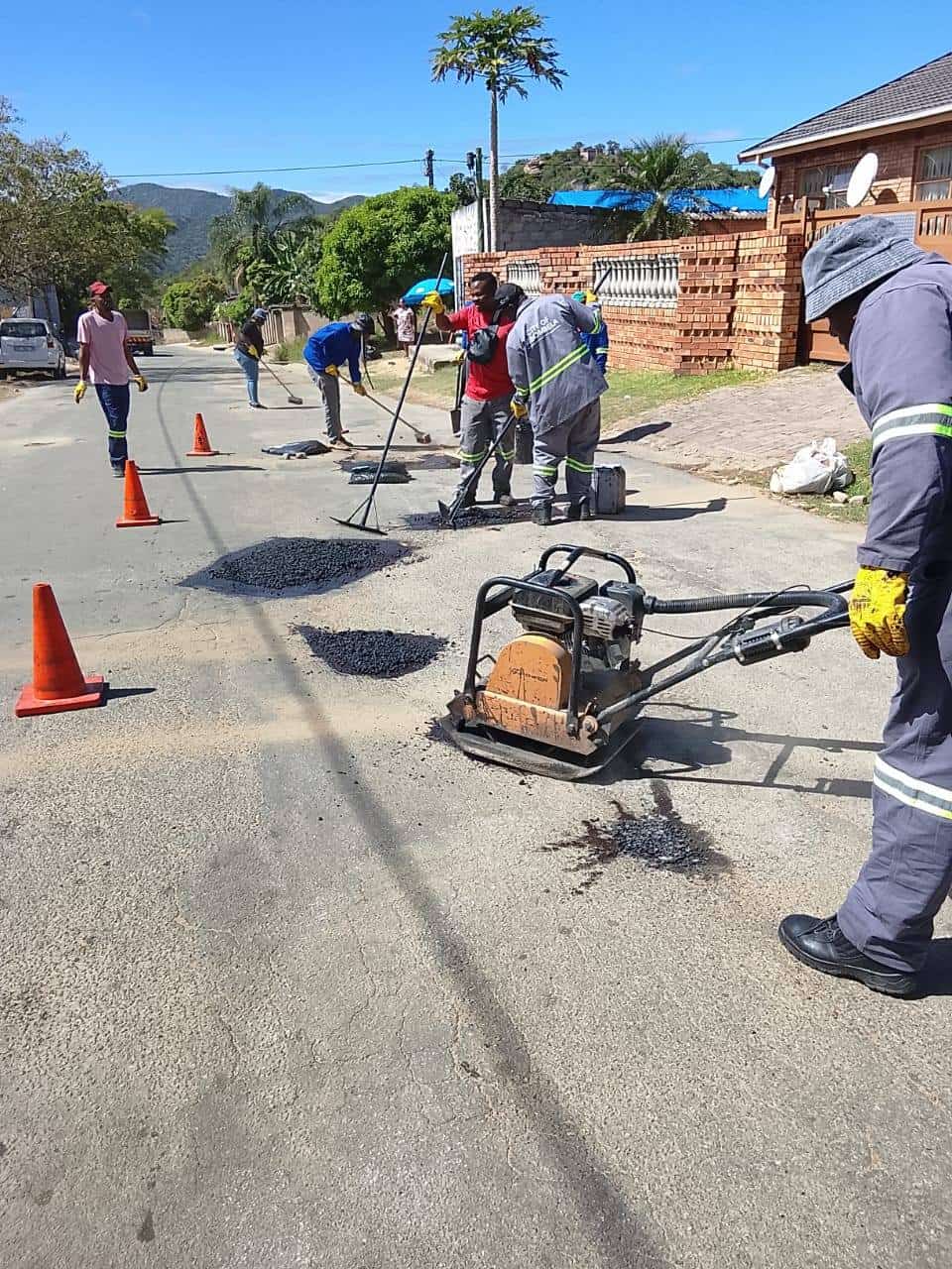 CoM officialS repairing potholes.