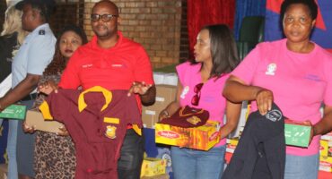DCM’s Remember Mmbengwa and the team from Ladies of Hope hold the uniforms that will be handed over.