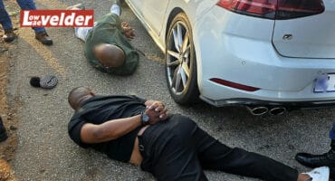 Two suspects lie on the ground.