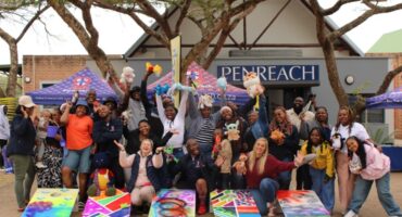Group of children and adults celebrating at Penreach toy drive event in Mbombela.