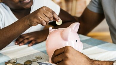 Dad and daughter saving money to piggy bank