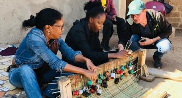 Tourists participate in traditional mat weaving.
