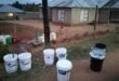 Buckets lined up for Sand River residents to collect water.