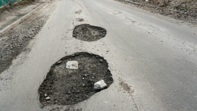 large pit with stones on the asphalt highway
