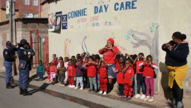 Alexandra SAPS officers Sergeants Vhudzini Kwinda and Violent Lebea interact with the children of the Connie Day Care Centre on Mandela Day. Photo: Sipho Siso