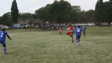 Benficas captain Johannes Komane (red) tries to control the ball as Tsutsumani Masters' William Senama (15) closes in – Alfred Makola (2) keeps a close watch. Photo: Sipho Siso