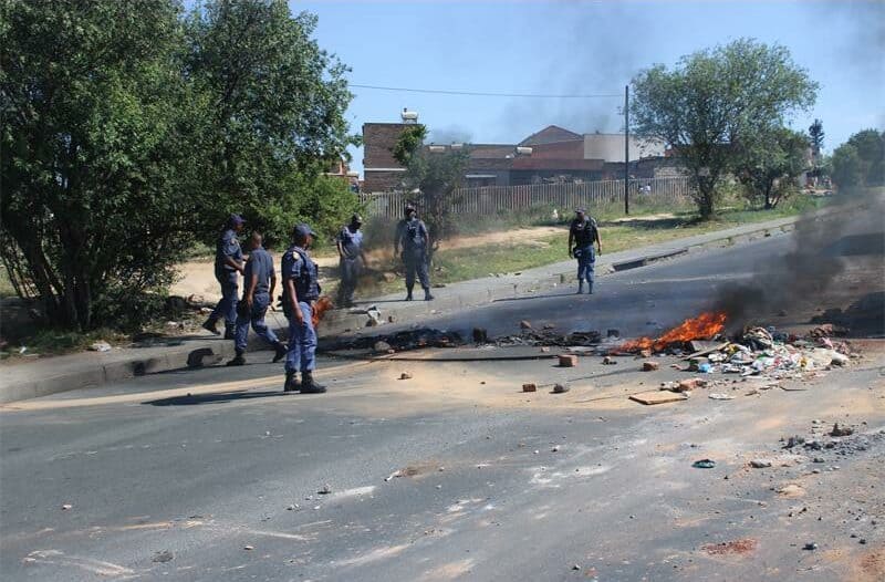 City Power has responded to ongoing protest action on London Road over electricity, stating that the residents are illegally occupying, and that they can't reinstate electricity until given the go ahead by the Provincial Department of Human Settlements and Housing.
