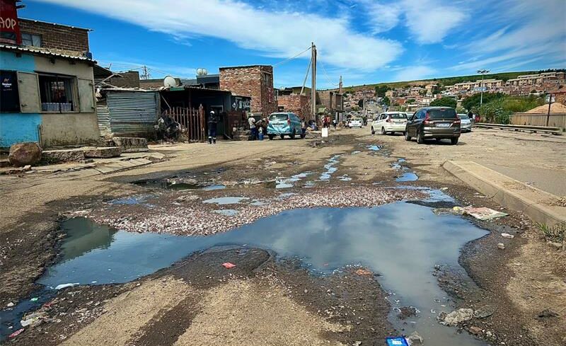 Florence Mophosho Road continues to decay due to wastewater and erosion while metered electricity remains out of reach for some Setswetla residents.