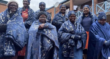 Elderly women wrapped in warm blankets during a winter support initiative for senior citizens