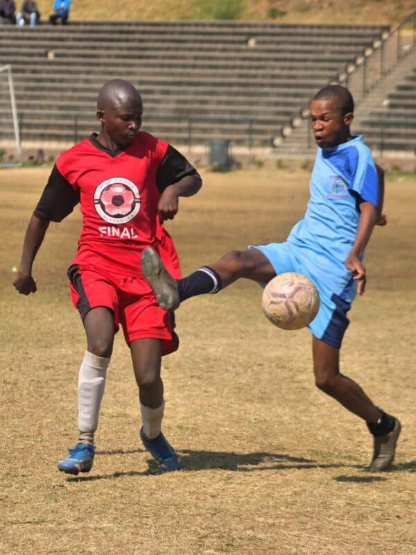 Super Stars’ Fizoluhle Mthethwa passes the ball as Mighty Heroes’ Thembalethu Ntsele comes rushing in to intercept it during their clash at 3 Square Sports Ground on August 9, 2026. Photo: Itumeleng Maloka