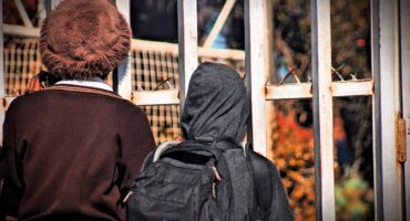 Two Minerva Hugh School learners stand outside the school gates in Alexandra on August 18, 2026. Photo: Itumeleng Maloka