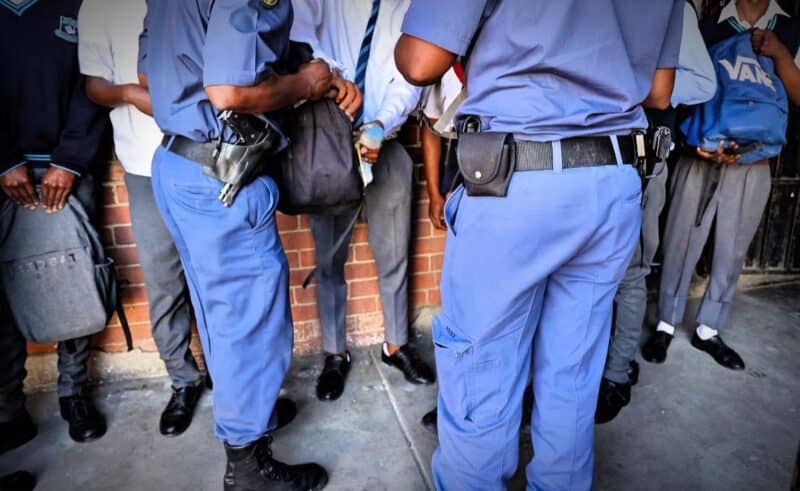 Police officers search learners at Realogile Secondary School in Alexandra. Photo: The Gauteng Department of Education/Facebook
