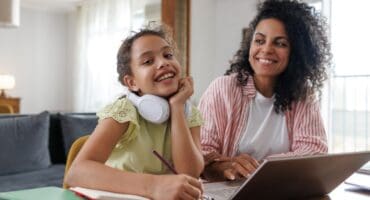 a mother and daughter on a laptop