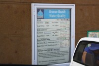 A municipal board at Bronze Beach states the last time the sea water was tested for e-coli and other bacteria was four months ago.