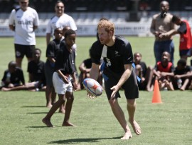 Prince Harry pulls off a deft pass in the tag rugby game at Kings Park. PHOTO: Howard Cleland