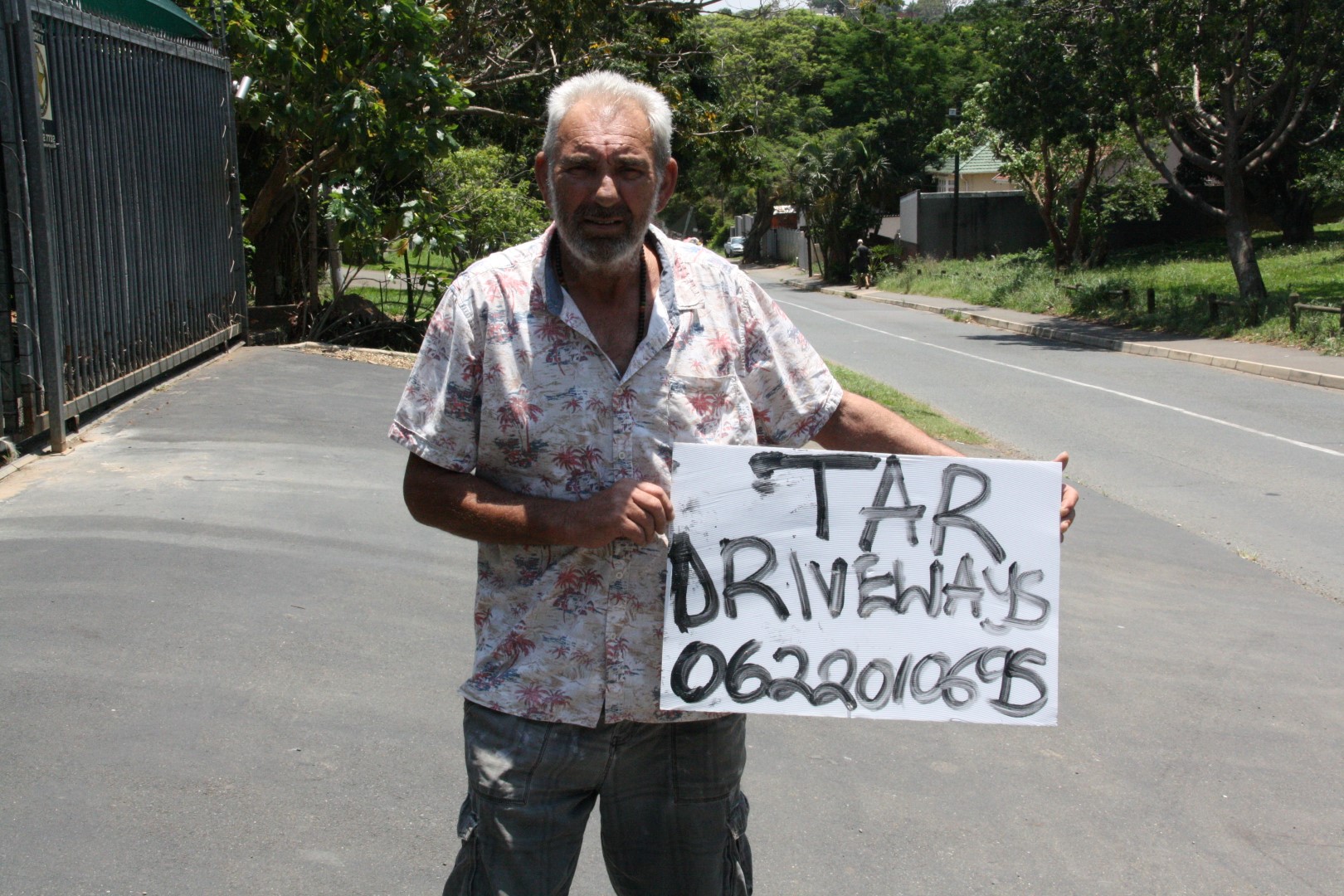 Parkhill resident, Derek van Rensburg, shows off one of the illegal advertising boards that dot the light poles and traffic lights around North Durban.