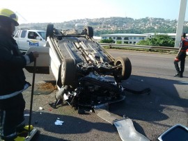 The overturned car on the busy freeway.