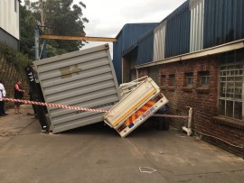 The ground underneath the truck and container collapsed causing it to tip over.