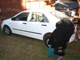 Brenda Widraj inspects the car which crashed through her sister's fence.
