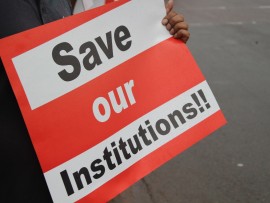 The signs included, 'Save Our Institutions', 'Stop the Looting' and 'Hands off Pravin'.