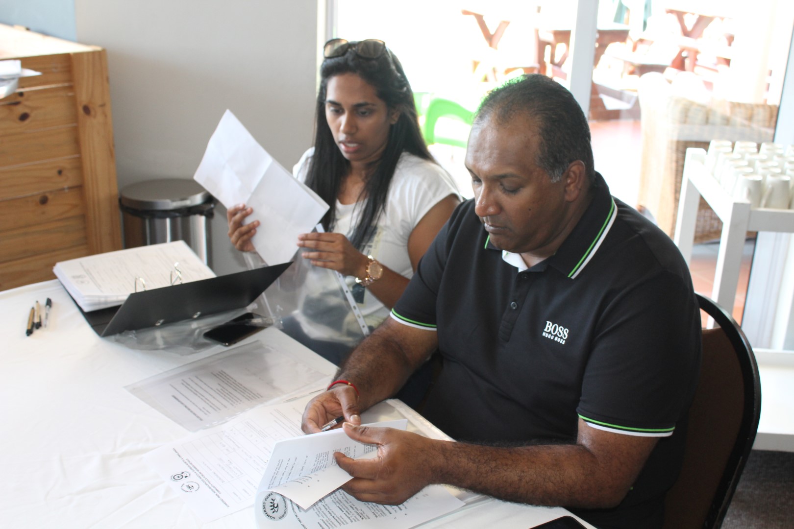 Members of the Somerset Park Neighbourhood Watch, Nureshka Viranna and Avilash Aniruth (chairman) help residents sign up for vehicle patrols to help curb crime in the area.