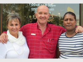 Mandy Radmore, Richard Gunning and Shantha Naicker stand outside the blackened store front, all that remains of the store.