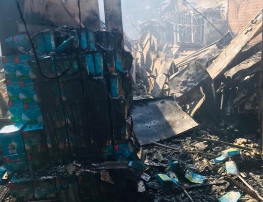 A scourched stack of long life milk is still recognizable amidst the rubble. 