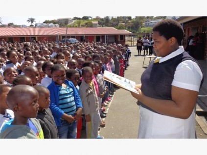 Port Shepstone Primary's head girl, Vuyokazi Mbumbe, reads an interesting article at the school assembly of approximately 1 000 pupils on literacy day.