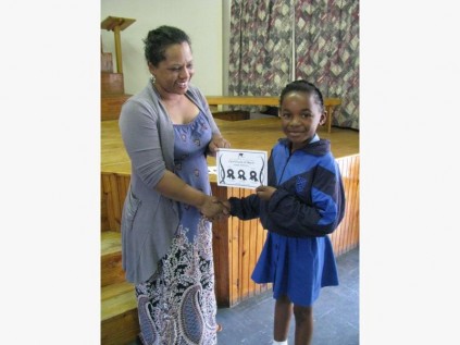 Junior Primary grade 2 teacher Vanessa Ogle congratulates Asisipho Ndovela on her silver mathematics Olympiad certificate.