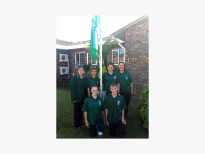 By die vlagparade is Suidie landsdieners (agter, van links) Kate O’Dwyer (onderwyser), Arno Vermaak (ondervoorsitter), Melissa Morrison (voorsitter), Rencia Morrison (klubleier), met Megan du Plessis (bestuurspan) en Tiaan du Plessis voor.