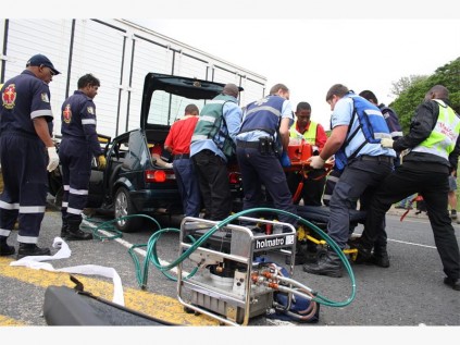 Emergency personnel work to help the injured motorist.