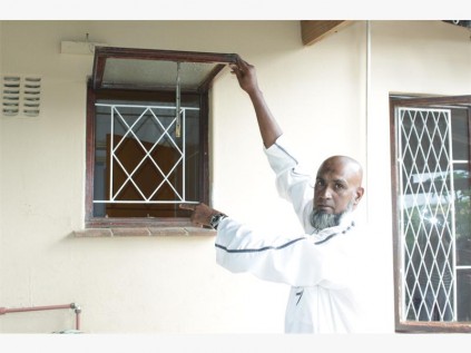  Ahmed Ismail points to the window where the thieves gained entry into his house.  