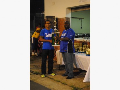 Anesh Dawlat (left), captain of Falcons, receives the George Raman Knockout Trophy from Devan Raman at the prize-giving.