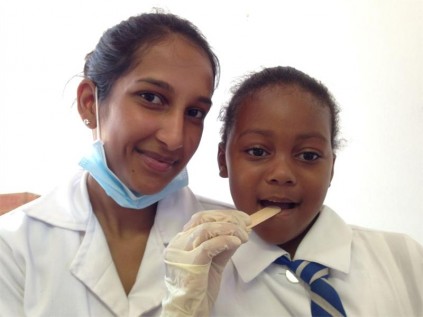 Dental student Kerissa Naicker examines Port Shepstone Primary pupil Saneliswe Nzimande's teeth.