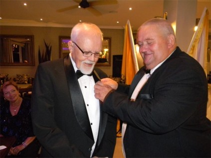George Leggett (left) receives his membership pin from his sponsor Kevin Ross. 