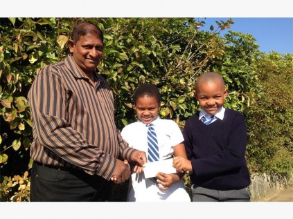  PSP pupils Zisanda Hlongwa (middle) and Kwanda Zindela hand over the cheque of R4000 to Pastor Reggie John of Bread of Heaven.