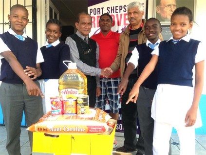 Port Shepstone Primary representatives (from left) Tsepiso Mkhwanazi, Naledi Jula, principal Sathananda Naidu, Nithia Nagiah, Derrick Ndwalane and Sxolile Mgobhozi hand over the food donation to Anthony Gonzalves (third from right) of the Recovery Centre.