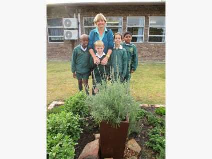 Gr 3 pupils (from left) Nyasha Mncube, Edward Bense, Katie Nortje and Shahid Bhoodram learn all about caring for the herb garden from Heather Bense (back).