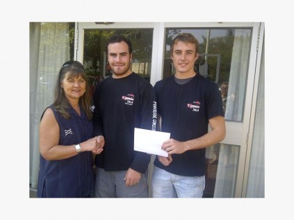 Port Edward Primary School principal Elva Collyer receives a cheque for R10 000 from past pupils, Cameron McBean (23) and Bronson Louw (19), organisers of the recent Powasol Umzumbe Extreme.  PHOTO BY PHILIPPA MAKEPEACE