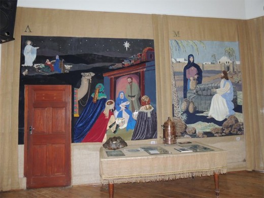 Panels depicting the Nativity and the New Testament story of the woman at the well. After the panel featuring the well was completed a small, forgotten spring that had once provided the church buildings with fresh water was discovered outside the hall, immediately behind the water-themed panel.