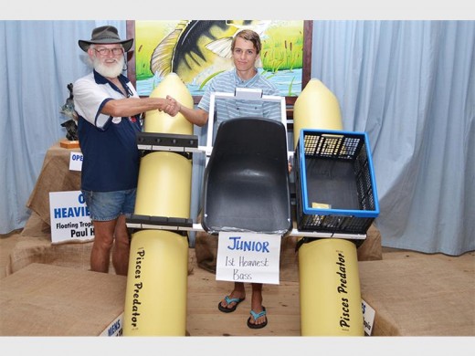 Great prize: Pem Reyneke, sponsor of a kick boat, congratulates Calvin Smith, who caught the biggest bass in the junior category. PHOTO BY DELLA ROW PHOTOGRAPHY & DESIGN