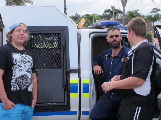 Interesting show: Sgt Rommel da Rosa chats to Suid-Natal Primary pupils Dimittrios Zwiegelaar (left) and Dylan Conradie (right) while narcotics dog Heeva waits patiently in the kennel.