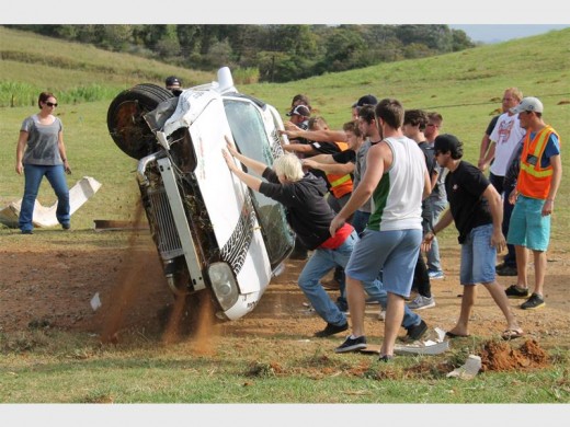 Helping hands: Drift drivers help Marisca Dyke, a young woman driver from the East Rand, to right her car after she overturned during a practice session. 5769vee