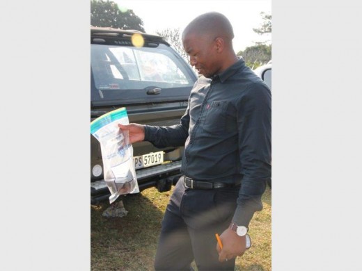 Constable Knowledge Cele with a brick that was collected near the crime scene. PHOTO BY VEE RAMSAYI
