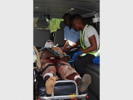 Paramedics and police assist a man who was attacked with a panga in Oslo Beach yesterday (Monday).