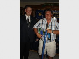 Soaked: Port Edward Country Club's chairman Steve Reed bags a few prizes - and a much needed brolly!