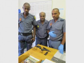Excellent work: Constable Mzakwe Makana (left), with Warrant Officer PC Naicker and Cst Rajiv Soothama with the confiscated fire arms and ammunition. 4048